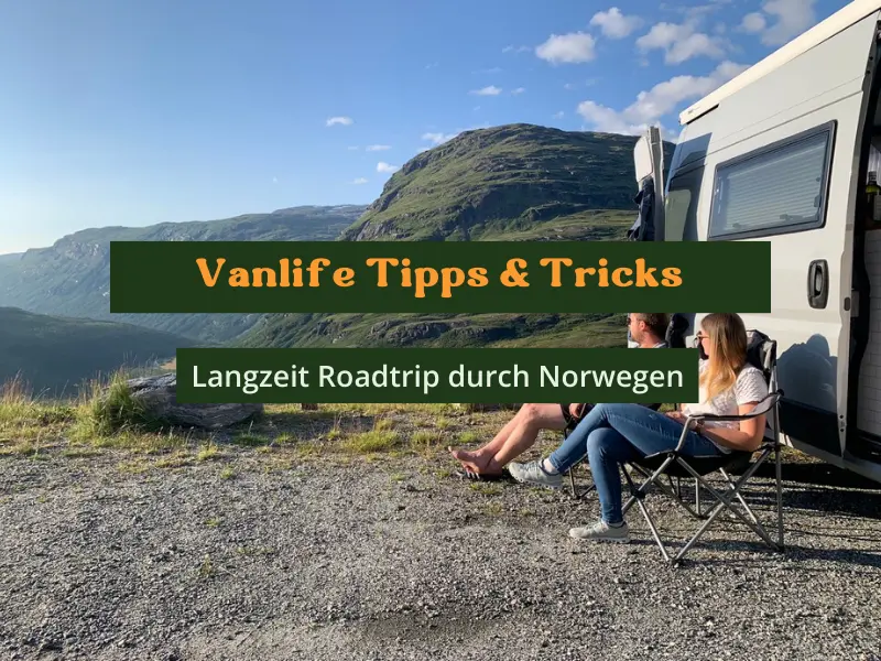 Vanlife: Zwei Menschen sitzen im Campingstuhl vor ihrem Campervan und schauen in die Natur und Berge.